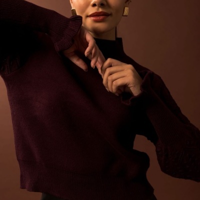 Mulher com camisola bordeaux de malha e saia preta