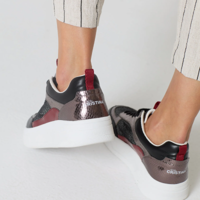 Tênis desportivos com sola branca e detalhes em cores escuras usados por uma pessoa