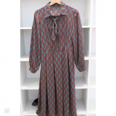 Vestido castanho com padrão azul numa estante branca