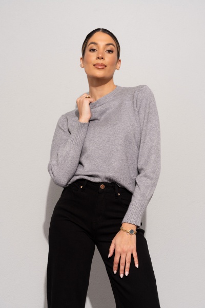 Mulher com camisola cinzenta de malha e calças pretas de cintura alta