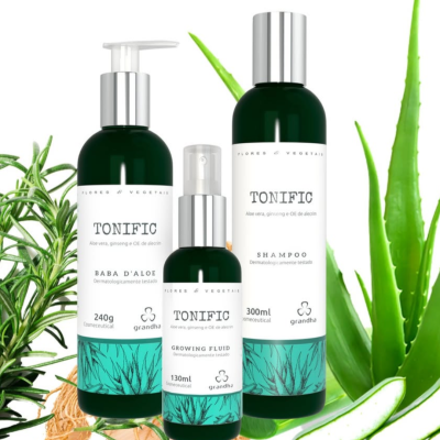 Três frascos verdes de produtos Tonific com rótulos brancos e plantas de aloe vera ao redor