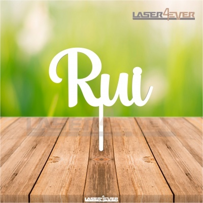 Topo de bolo branco com nome Rui sobre mesa de madeira