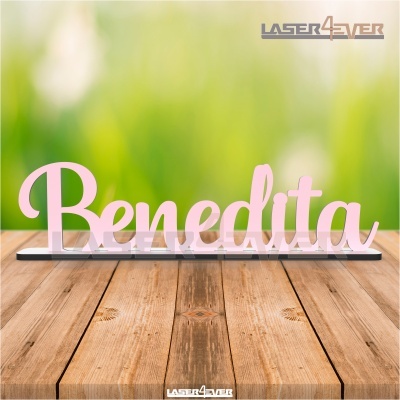 Objeto decorativo rosa claro com a palavra Benedita em base preta sobre madeira