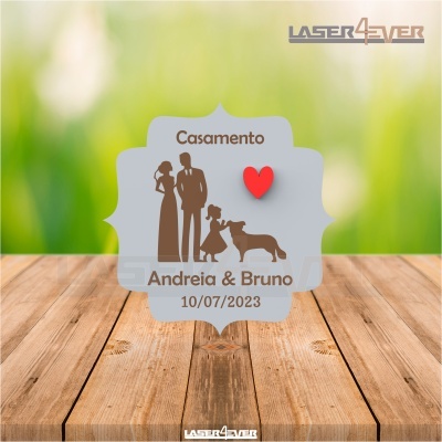 Convite de casamento com casal, criança, cão, texto e coração vermelho numa superfície de madeira