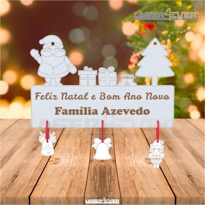 Placa de Natal em madeira com Pai Natal, árvore, presentes e texto em castanho, com três ornamentos pendurados.