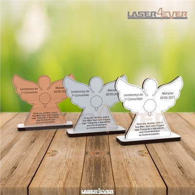 Três lembranças em forma de anjo em acrílico com texto gravado, em cima de madeira clara