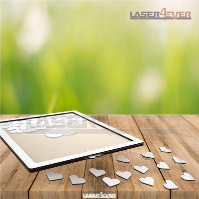 Moldura branca com moedas brancas em forma de coração sobre mesa de madeira