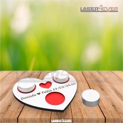 Suporte de velas em forma de coração branco e vermelho com inscrições numa mesa de madeira