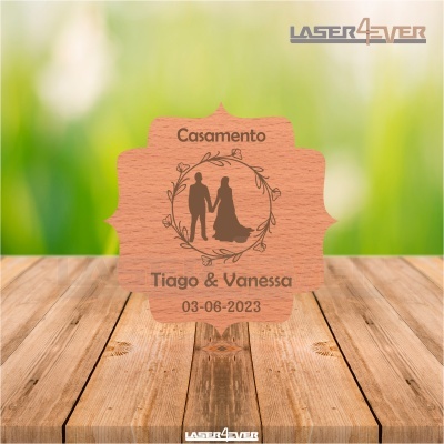 Placa de madeira clara com gravação de casal, texto de casamento e data