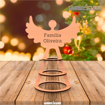 Decoração de anjo em madeira com texto Família Oliveira sobre mesa de madeira e fundo natalício desfocado