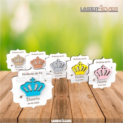 Marcadores de mesa em madeira com coroas coloridas e texto gravado para evento Profissão de Fé.