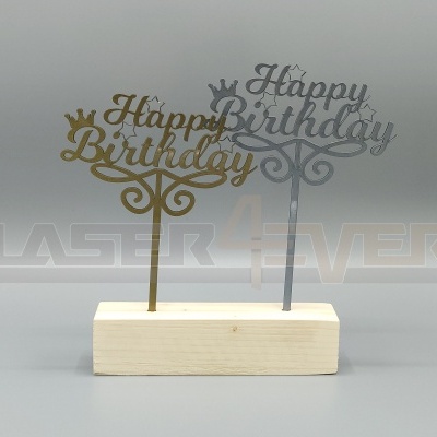 Dois toppers de bolo dourado e prateado com a frase 'Happy Birthday' em caligrafia sobre base de madeira