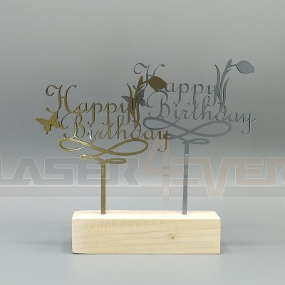 Topo de bolo 'Happy Birthday' em metal dourado e cinzento numa base de madeira clara