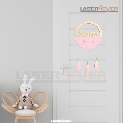 Suspensão decorativa de porta com nome Sara e penas penduradas em porta branca, cadeira de vime com boneca de peluche ao lado