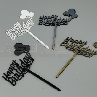 Quatro toppers de bolo 'happy birthday' em quatro cores diferentes sobre fundo cinza.