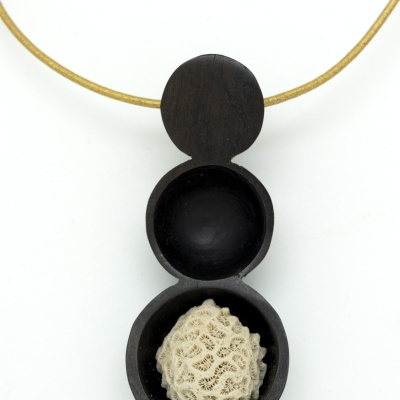 Colar com pendente em madeira preta e elemento branco rendado em fundo branco