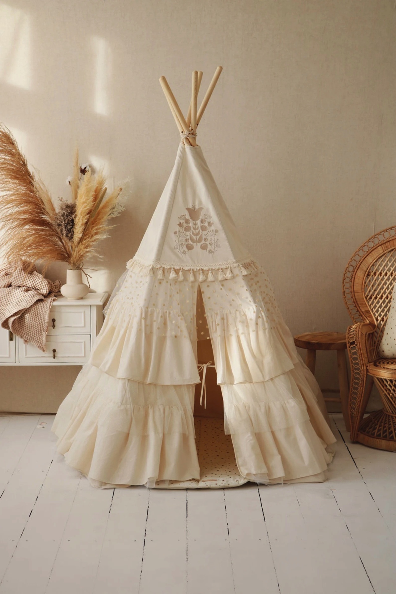 Tenda infantil creme com bordados e babados em ambiente com móveis de madeira e decoração natural