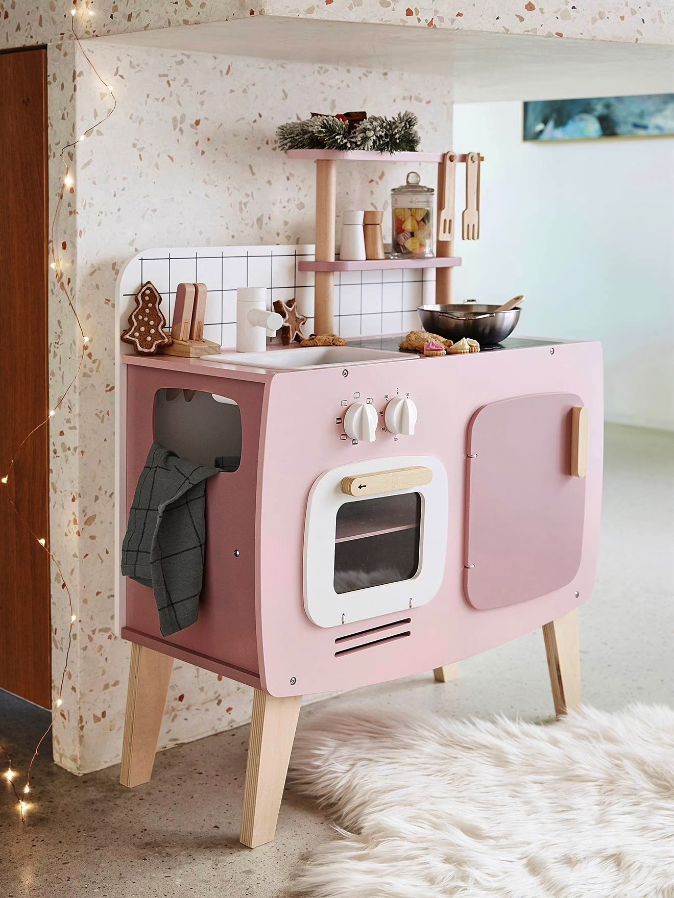 Cozinha de brincar infantil rosa com madeira clara e utensílios de cozinha