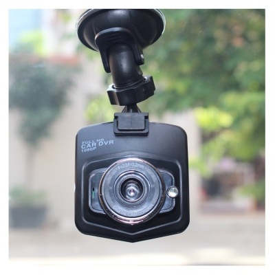 Câmara DVR para carro preta com lente circular montada num vidro por ventosa