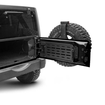 Porta traseira aberta de um Jeep preto com suporte de pneu e prancha preta de metal