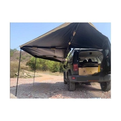 Automóvel com toldo exterior preto estendido em terreno de terra