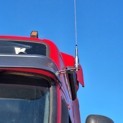 Cabine de camião vermelha com antena metálica e espelho retrovisor