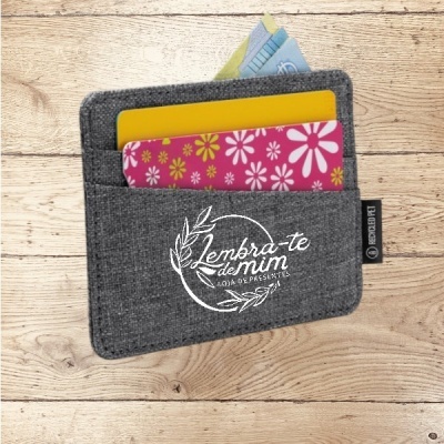 Carteira cinzenta com cartões coloridos e notas de dinheiro sobre madeira