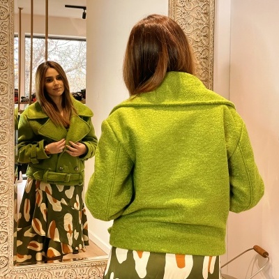 Casaco verde felpudo e saia com padrão abstrato refletidos em espelho ornamentado