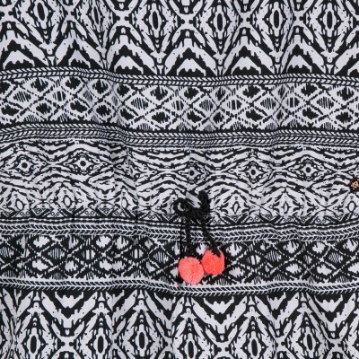 tecido preto e branco com cordão e pompons vermelhos