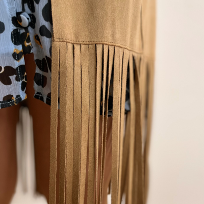 Casaco camel com franjas longas e saia com padrão animal print