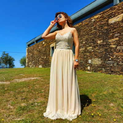 Vestido longo creme com corpete bordado e saia fluida ao ar livre