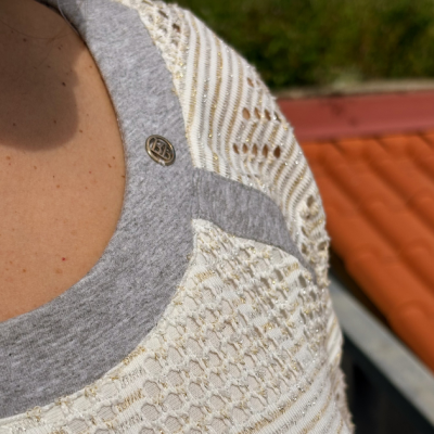 Blusa branca com padrão de malha e gola cinza com botão metálico BPC