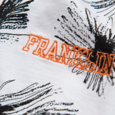 Tecido branco com padrão floral preto e texto bordado 'FRANKLIN' em laranja