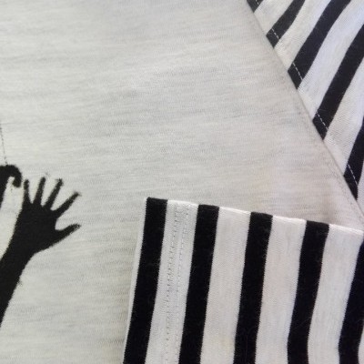 Camisola branca com riscas pretas nas mangas e detalhe de mão preta