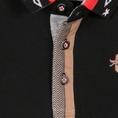 Pormenor de camisa polo preta com botões e gola com detalhes coloridos