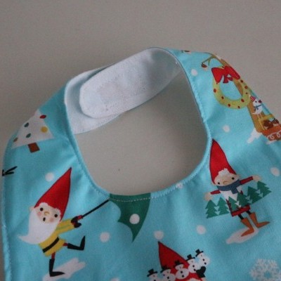 Babete para bebé azul claro com gnomos vermelhos e neve