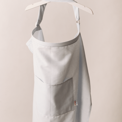 Avental listrado azul claro e branco pendurado em cabide branco