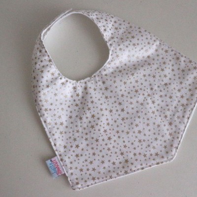 Babete branco com estampado de estrelas cinzentas sobre superfície cinzenta