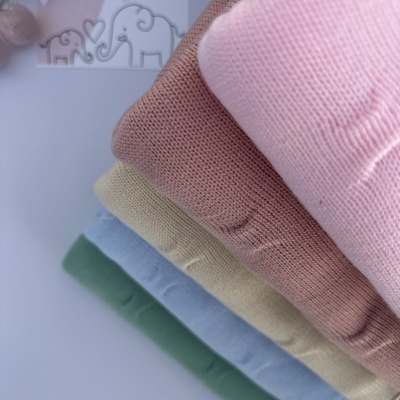 Manta de malha forrada e decorada com laço