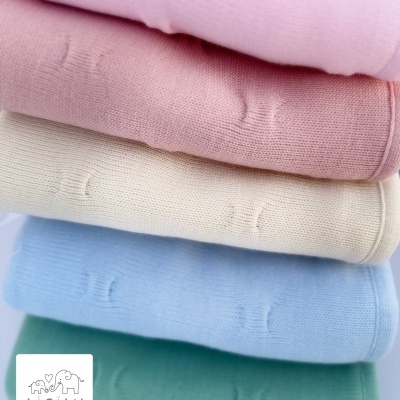 Manta de malha forrada e decorada com laço