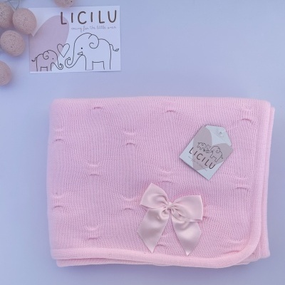 Manta de malha forrada e decorada com laço