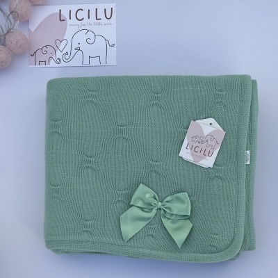 Manta de malha forrada e decorada com laço