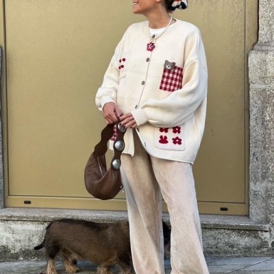 Mulher com roupa casual e mochila, ao lado de um cão em ambiente urbano