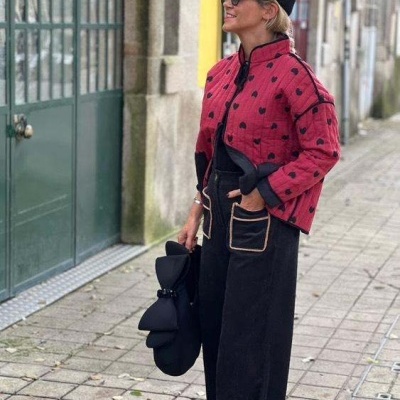Mulher com casaco acolchoado vermelho e calças pretas largas na rua