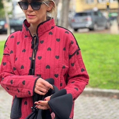 Casaco acolchoado rosa com corações pretos e gola alta em ambiente urbano