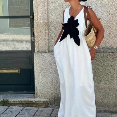 Mulher com vestido longo branco e laço preto em ambiente urbano