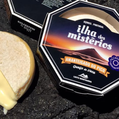 Queijo macio amanteigado do Pico em embalagem octogonal preta com texto branco e laranja, queijo cremoso aberto