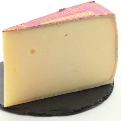 Pedaço de queijo com casca rosa sobre base preta