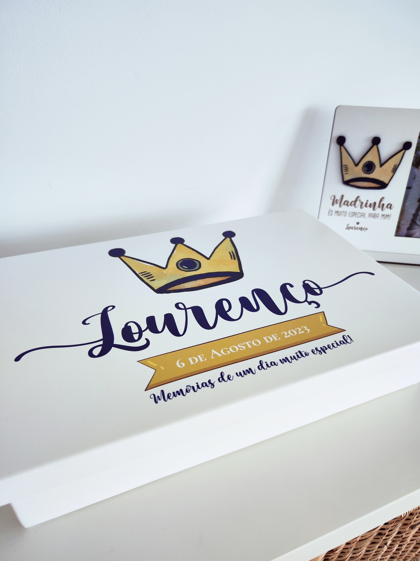 caixa branca personalizada com nome Lourenço, texto e coroa desenhada, com moldura ao fundo