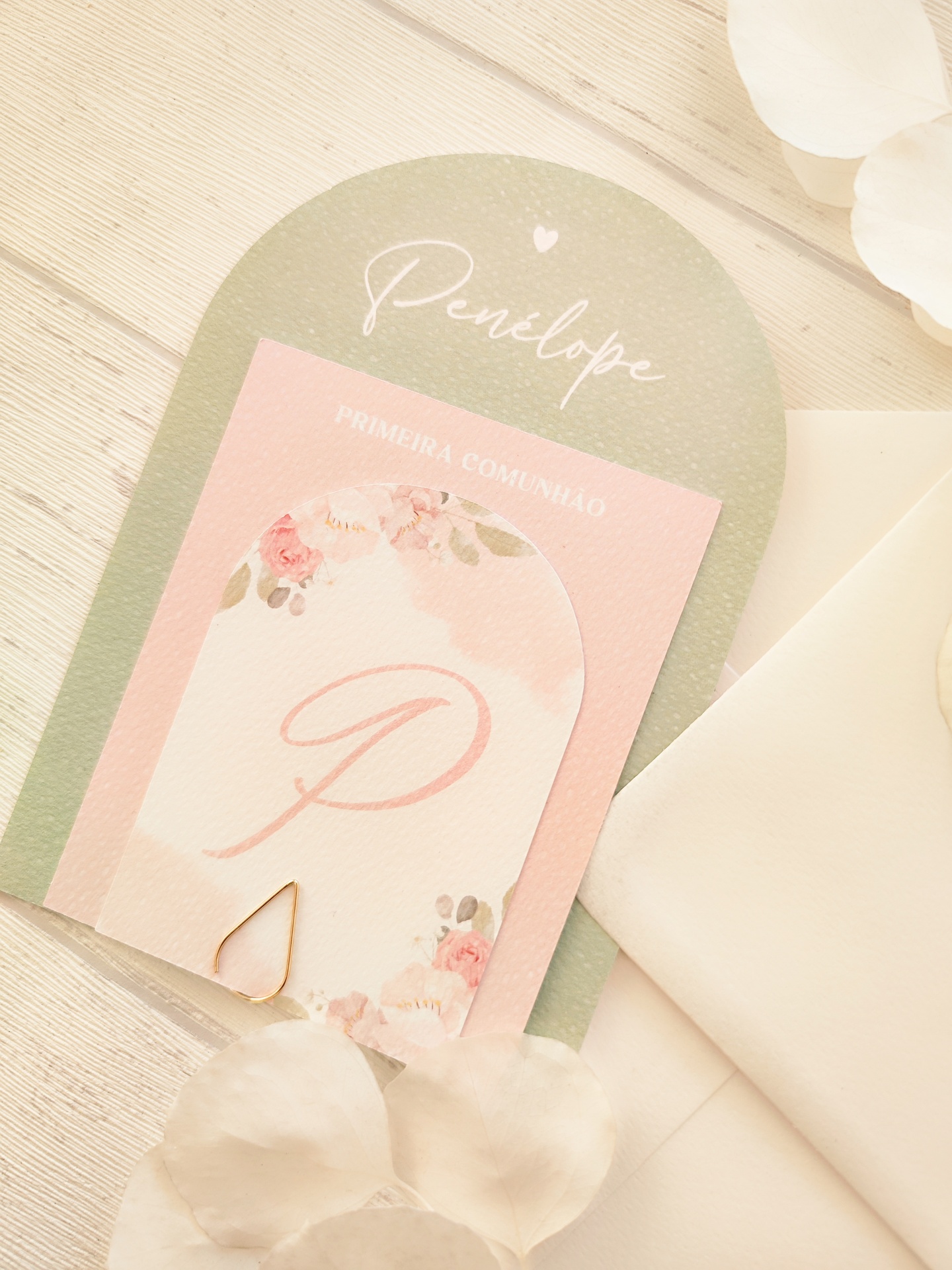 Convite delicado para primeira comunhão com design floral e texto, sobre mesa clara